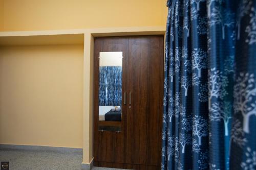 a room with a wooden door and a mirror at Reunion Regal Villa in Udupi