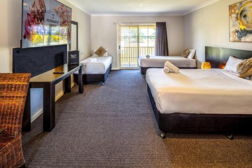 ein Hotelzimmer mit 2 Betten und einem Sofa in der Unterkunft Stockmans Motel in Tamworth