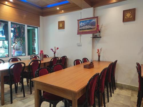 a conference room with wooden tables and chairs at Hotel Tawang Regency in Tawang