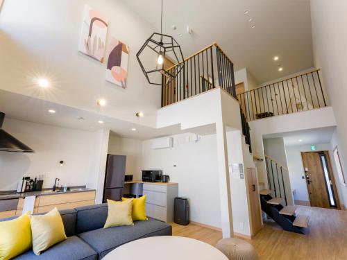a living room with a blue couch and a staircase at Rakuten STAY VILLA Fuji Kawaguchiko Forest 2LDK with sauna and terrace-Pet Friendly- in Fujikawaguchiko