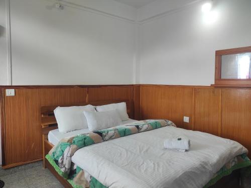a bedroom with two twin beds and a window at Hotel Tawang Regency in Tawang