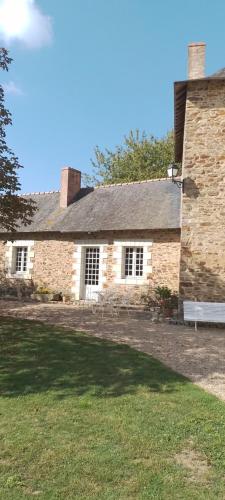 a brick house with a bench in front of it at Chambre d'hôte à la Gilardière 