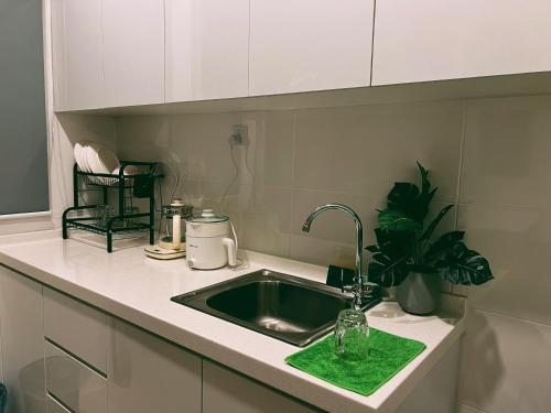 un fregadero con una esponja verde al lado en Stylish 2 Bedroom Apartment by Thirteen Residence at ITCC Manhattan suites TR09, en Donggongon