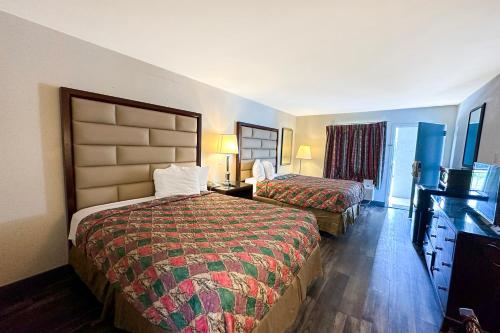 ein Hotelzimmer mit 2 Betten und einem TV in der Unterkunft Executive Inn By OYO Ridgeway I-77 in Ridgeway