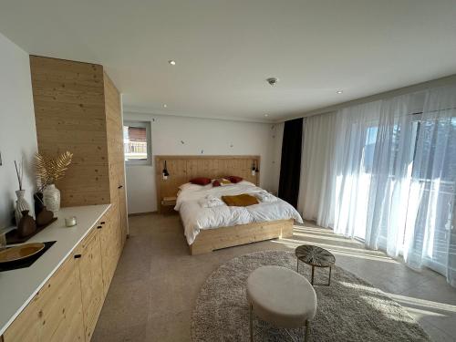 sypialnia z łóżkiem i dużym oknem w obiekcie John's Lodge w mieście Les Collons
