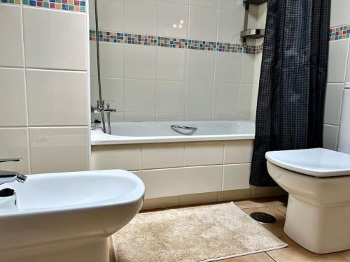 a bathroom with a sink and a toilet and a tub at Апартамент с 1 спальней в La Tejita (El Medano) in Granadilla de Abona