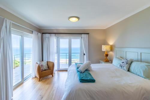 a bedroom with a bed with a view of the ocean at Comfy Holiday Home - No Loadshedding - By Peak Management in Wilderness