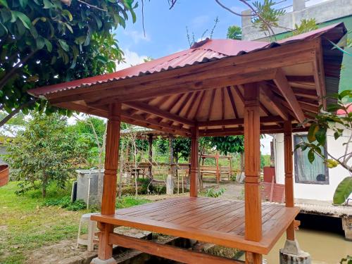 a wooden gazebo with a roof at Montong Raden camping ground in Midang