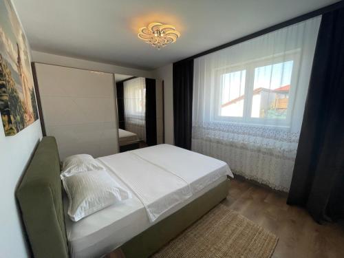 ein Schlafzimmer mit einem weißen Bett und einem Fenster in der Unterkunft Lilo HOME in Sibiu