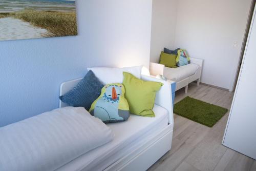 クックスハーフェンにあるStrandhaus-Nordseebrandung-Fewo-B3-4の白いソファ、黄色と青の枕が備わる客室です。