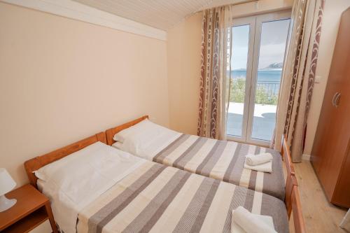 a bedroom with a bed with a view of the ocean at Apartments Ostrea - Caska in Novalja
