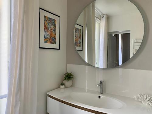 a bathroom with a sink and a mirror at Le Ciel de Paris - Montparnasse & Jardin du Luxembourg in Paris