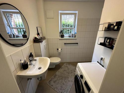 bagno con lavandino, servizi igienici e specchio di Alstertraum mit Garten und priv. Wasserzugang ad Amburgo