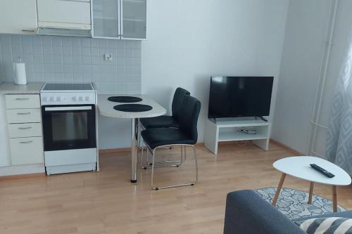 eine kleine Küche mit einem Tisch und einem TV in der Unterkunft Kotimaailma Apartments Sammonkatu 6 in Jyväskylä