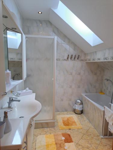 łazienka z prysznicem, wanną i umywalką w obiekcie Appartement Schober w mieście Kukmirn