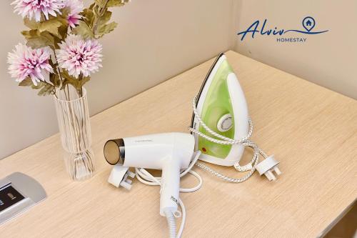 a phone on a table next to a vase of flowers at Alviv 99 Suites I Family Suite I 4-7 pax I 5minsMelakaCruise I JonkerSt in Melaka