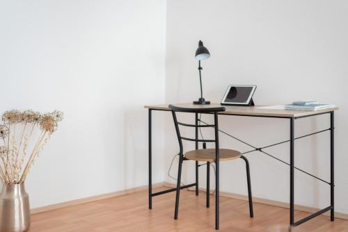 a desk with a laptop and a chair at Prague - Karlin Apartments in Prague