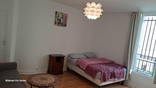 - une petite chambre avec un lit et un lustre dans l'établissement Appartement 9ème, à Paris