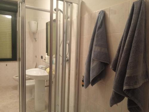 een badkamer met een douche, een wastafel en een toilet bij camere Olmedo - 10 minuti da Alghero in Olmedo