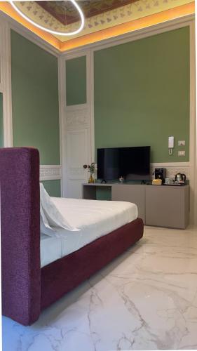 a bedroom with a bed and a flat screen tv at Palazzo Maqueda in Palermo