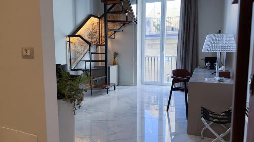 a living room with a staircase and a table and chairs at Palazzo Maqueda in Palermo
