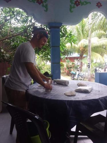 a man standing in front of a table at Ella's Place Salang Tioman in Tioman Island