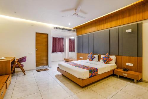 a bedroom with a bed and a desk in it at FabHotel Prime Blue Moon in Gandhinagar