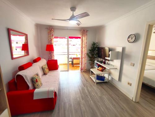 salon z czerwoną kanapą i łóżkiem w obiekcie Apartment in Puerto de Santiago. Jardines del Mar w mieście Puerto de Santiago