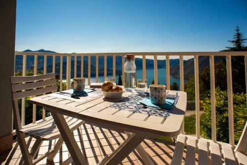 a table on a balcony with a view of the ocean at Italian Vacation Homes - Lucy's House in Parzanica