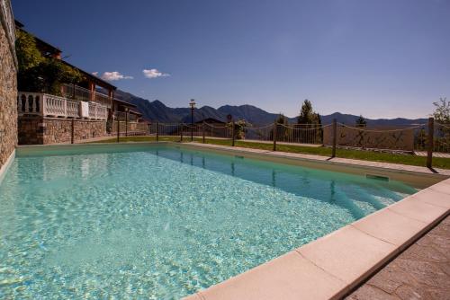 a swimming pool with blue water in front of a building at Italian Vacation Homes - Lucy's House in Parzanica
