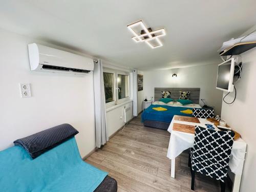 a small bedroom with a bed and a table at Balcsitthon Apartmanok in Siófok
