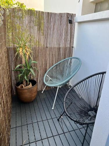 une terrasse avec 2 chaises, une table et une plante dans l'établissement Le Cozy - T3 Tout Confort - Métro Barrière Paris, à Toulouse