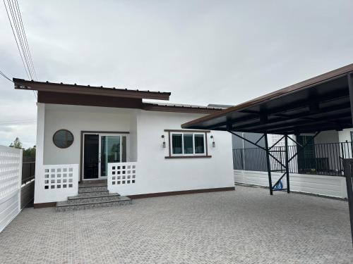 a small white house with a porch and stairs at GoodDay Poolvilla UdonThani บ้านพูลวิลล่ากู๊ดเดย์ อุดรธานี in Udon Thani