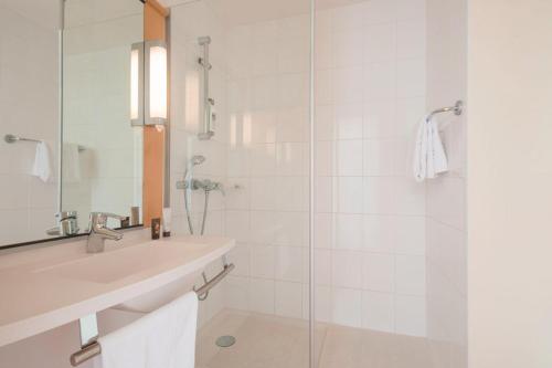 a bathroom with a sink and a glass shower at ibis Nantes Centre Gare Sud in Nantes