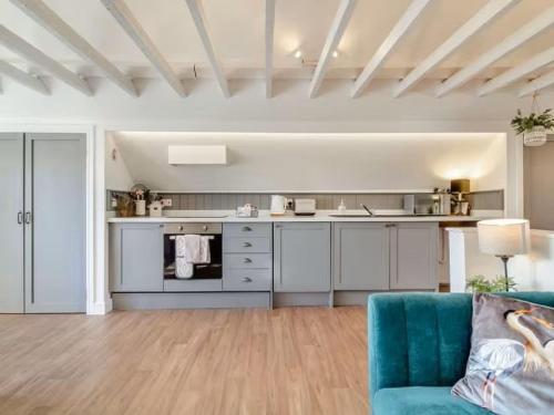 a kitchen with a blue couch in a living room at Studio Flat in Heritage Triangle, Diss in Diss