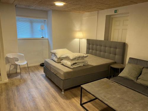uma sala de estar com um sofá e uma cadeira em The Italian House 2 em Aalborg