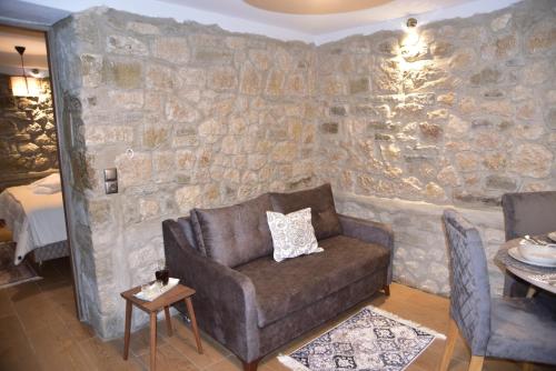 a living room with a couch and a stone wall at Elen's Suites Pramanta in Pramanta