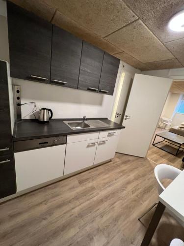 een keuken met witte kasten en een wastafel bij The Italian House 2 in Aalborg