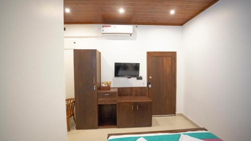 a room with a tv and a desk with a television at JAMUNA VILLA in Jaffna