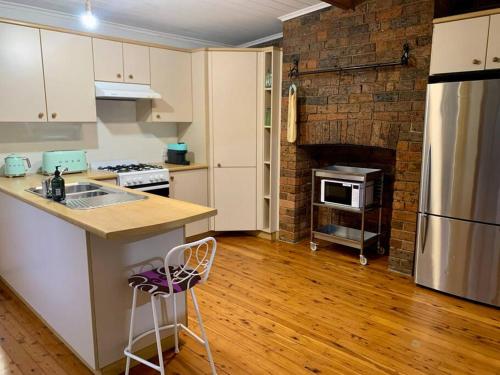 a kitchen with a counter and a brick fireplace at Quarryman Cottage @ 102 in Bowral