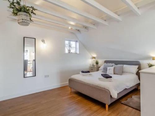 a bedroom with a large bed in a white room at Studio Flat in Heritage Triangle, Diss in Diss