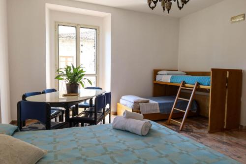 ラメーツィア・テルメにあるAngotti FamilyHouseのベッドとテーブル付きの部屋、二段ベッド付きの部屋