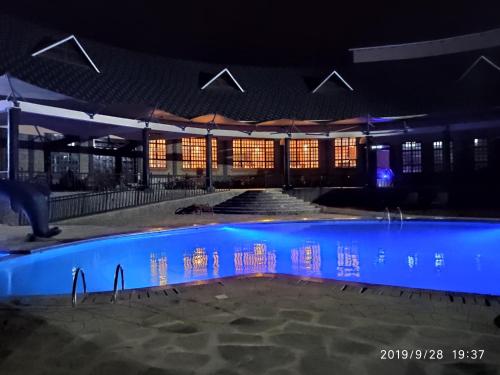 a building with a swimming pool at night at Kiikalloh Grand Resort in Machakos