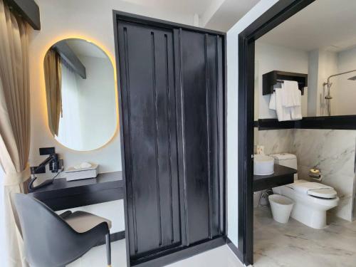 a bathroom with a black door and a toilet at LHC HOTEL AND RESORT in Pattaya Central