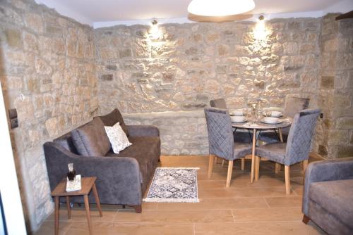 a living room with a table and chairs and a stone wall at Elen's Suites Pramanta in Pramanta