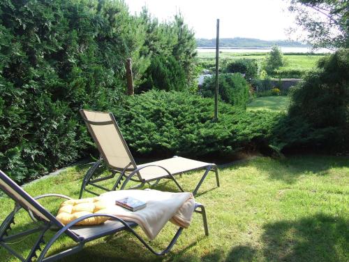 a chair sitting on the grass in a yard at Balm, Fewo "Balmer See" in Balm