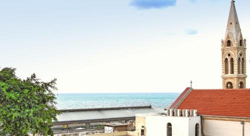 a church with a steeple and the ocean behind it at Deluxe 2BR Apt w Pool in Historical Jaffa by Sea N' Rent in Tel Aviv