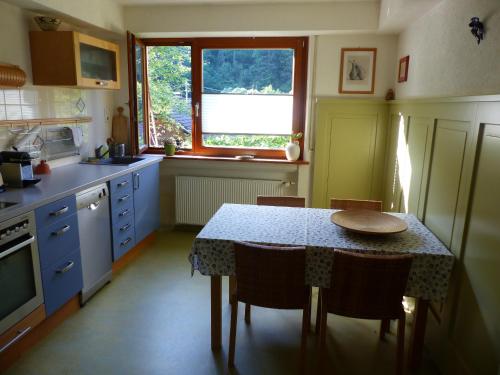 a kitchen with a table with chairs and a window at Ferienwohnungen in Schönmünzach in Baiersbronn