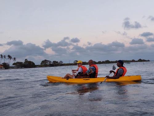 a group of people in a yellow kayak in the water at Kalpitiya Chalets by Thilanka in Kalpitiya