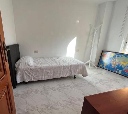 a bedroom with a bed and a flat screen tv at Casa adosada junto a la playa de El Perelló in Sueca